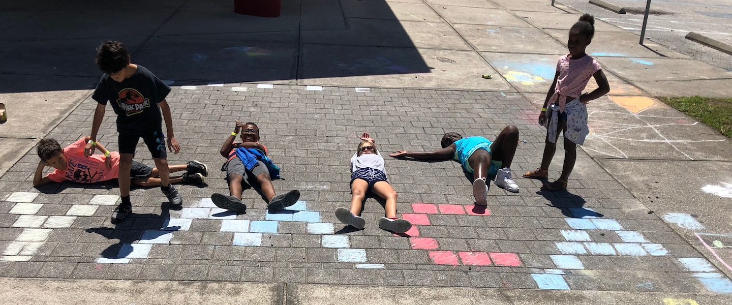 kids playing with chalk spelling ymca