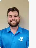 headshot of male personal trainer wearing blue YMCA polo beige background